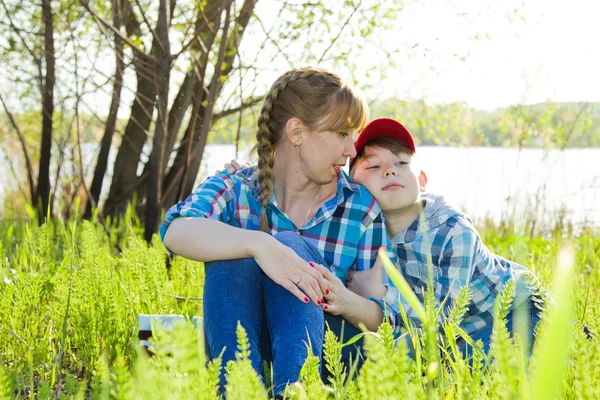 Mère et fils assis sur l'herbe — Photo