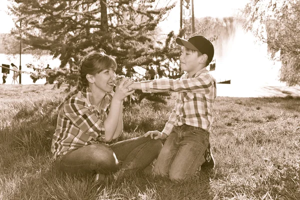 Mère et fils assis sur l'herbe — Photo