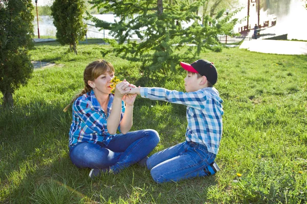 Matka i syn, siedząc na trawie — Zdjęcie stockowe