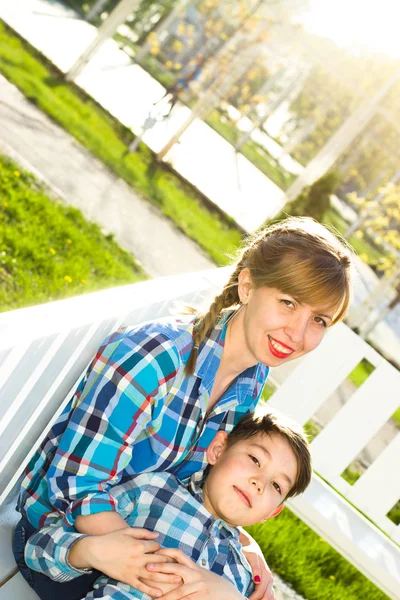 Mère et fils sur le banc dans le parc — Photo