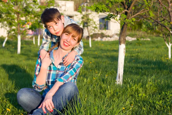 Mère et fils assis sur l'herbe — Photo
