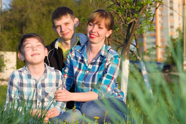 Parkta çimlerde oturan aile — Stok fotoğraf