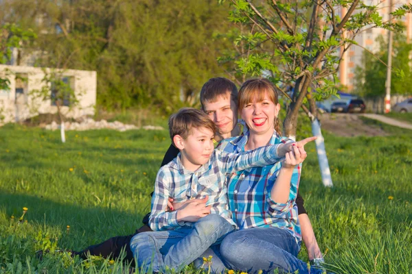 Família sentada na grama no parque — Fotografia de Stock