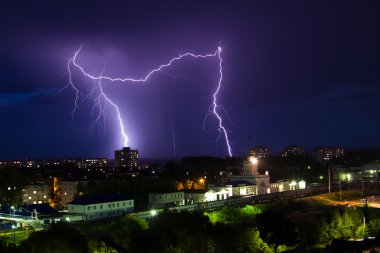 Mor ışık şehir üzerinde şimşek fırtına