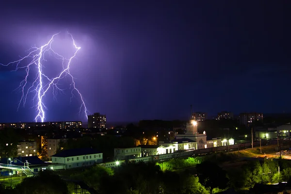 Blitzlichtgewitter über der Stadt in violettem Licht — Stockfoto