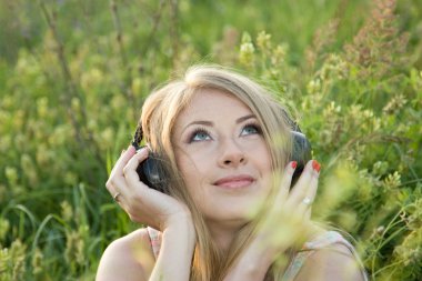 Güzel kız çayırda müzik dinler