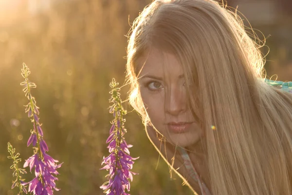 美しい金髪と夕暮れの花 — ストック写真