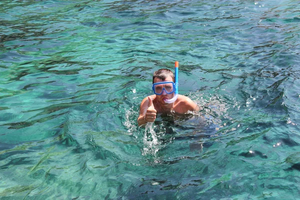 Um homem com uma máscara flutua perto das cavernas do mar — Fotografia de Stock