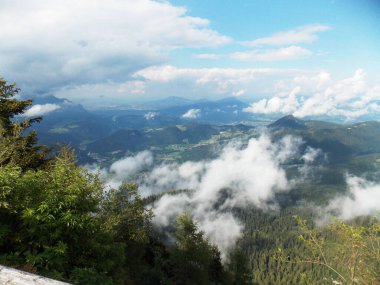 Dağın tepesinden dağlara ve ormanın güzel manzarası. Yazın sisli, mavi gökyüzüne karşı.