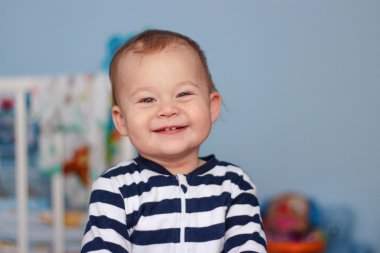 Sevimli küçük çocuk yatağı üzerinde oturan