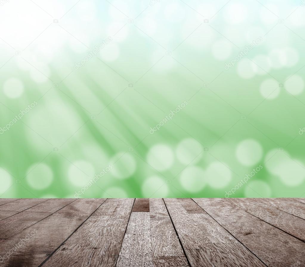 Wood table top on green blurred bokeh light and sun ray