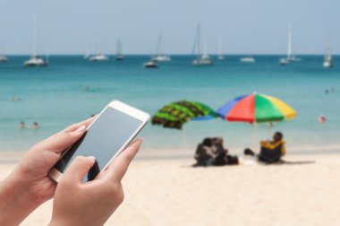 Smartphone üst bulanık mavi denizde kullanarak kadınlar 