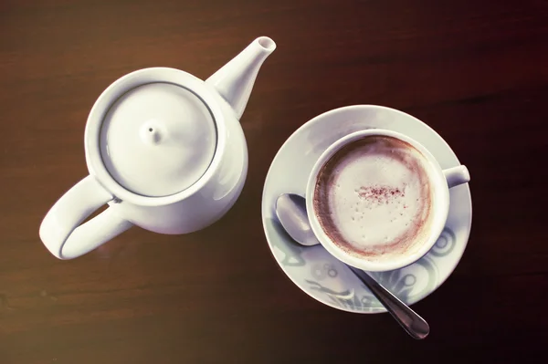 Чашка кофе с горячим чайником на темной деревянной — стоковое фото