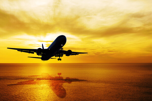 Seascape and sky sunset with airplane