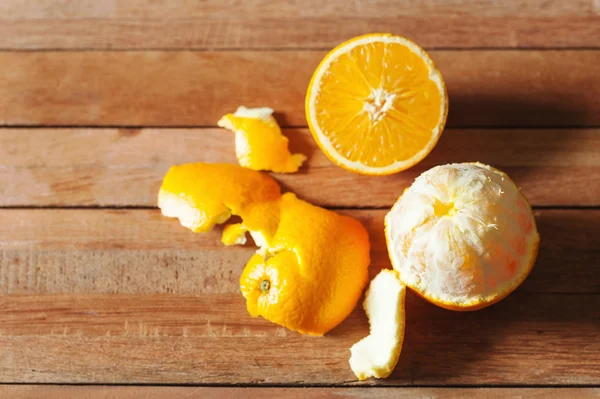 Orangenfrüchte und Scheiben auf Holz — Stockfoto