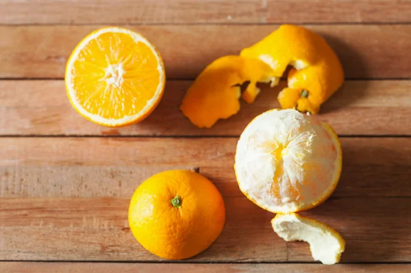 Orangenfrüchte und Scheiben auf Holz — Stockfoto