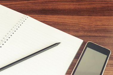 Defter ile cep telefonu ve kalem