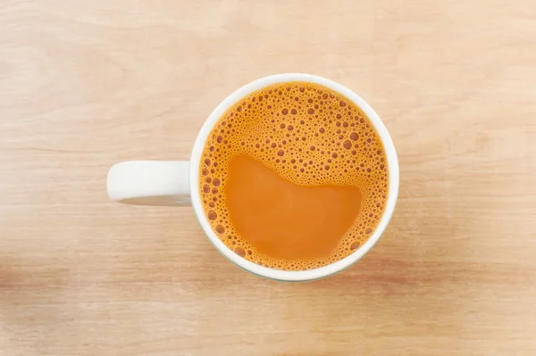 Tablo üzerinde beyaz bir bardak sıcak süt çay — Stok fotoğraf