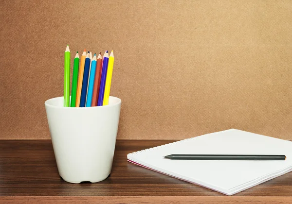 Lápiz colorido en taza blanca con bloc de notas —  Fotos de Stock