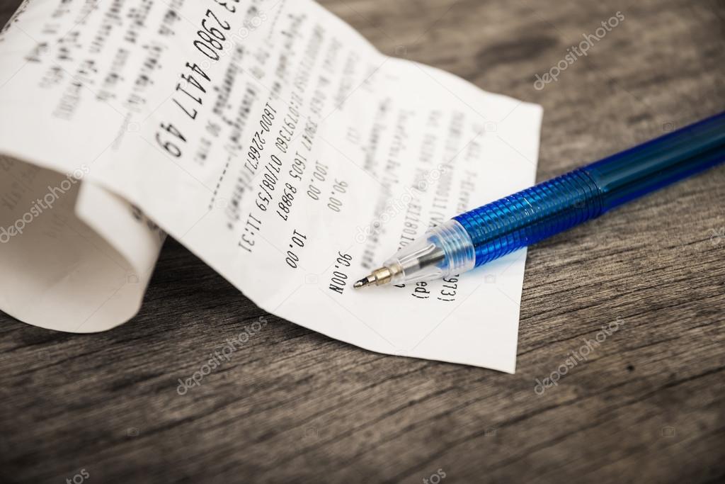Bill and pen on wooden table