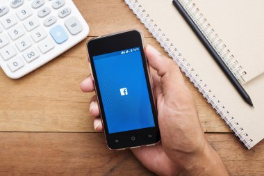 El adam holding smartphone