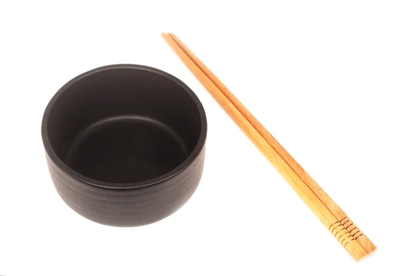 Black ceramic bowl with wooden shopsticks isolated — Stock Photo, Image