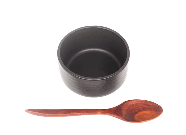 Black ceramic bowl with wooden spoon isolated — Stock Photo, Image