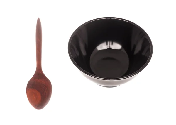 Black ceramic bowl with wooden spoon isolated — Stock Photo, Image