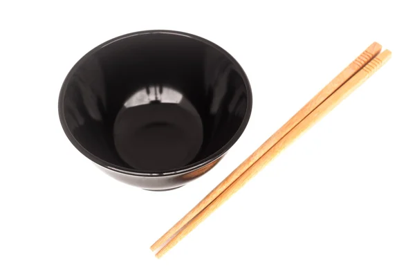 Black ceramic bowl with wooden shopsticks isolated — Stock Photo, Image