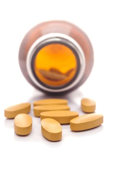 Pills capsule spilling out of a bottle — Stock Photo, Image