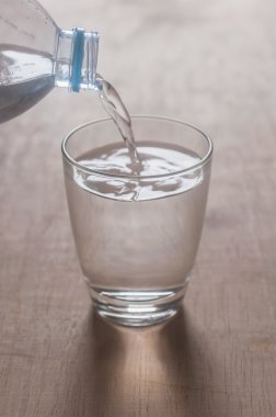 Ahşap arka plan üzerinde cam su sıçramasına su