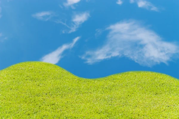 Πράσινο γρασίδι σε γη με το γαλάζιο του ουρανού και σύννεφο φόντο — Φωτογραφία Αρχείου