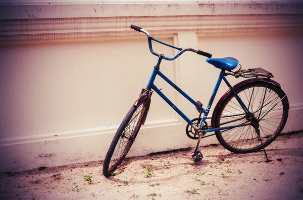 Bicicleta velha na parede em corpo escuro, tom vintage — Fotografia de Stock