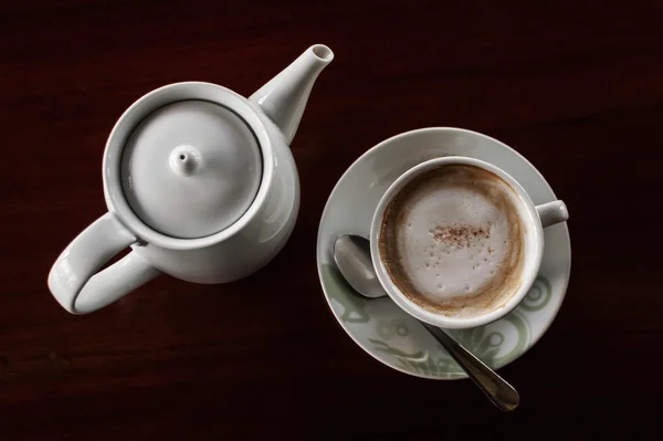 Xícara de café com panela de chá quente em uma madeira escura — Fotografia de Stock