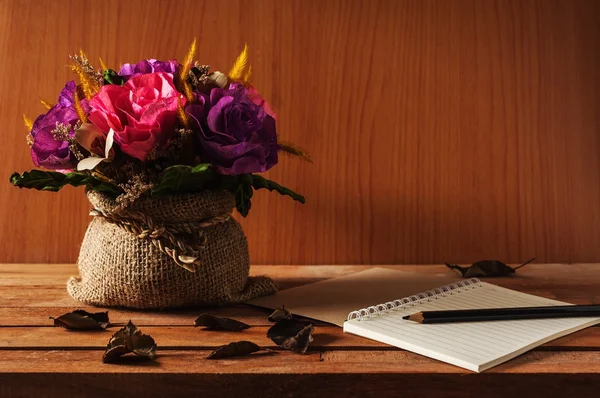 Tavolo dello scrittore, Blocco note con matita e fiore su tavola di legno — Foto Stock