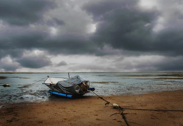 Sea and beach with fishing boat and sky storm cloud