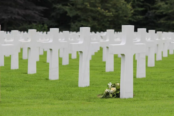 Білі хрести на американському цвинтарі з квітами — стокове фото
