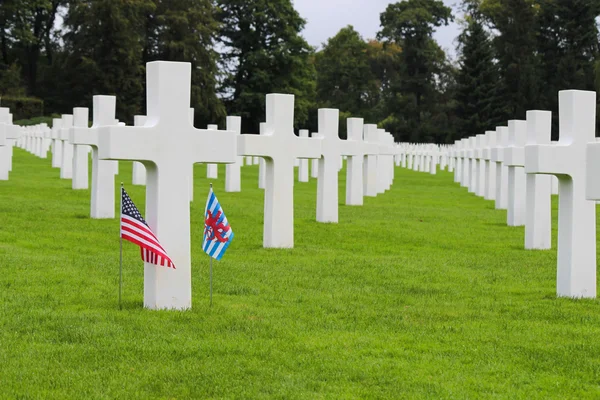 Білі хрести на американському цвинтарі з прапорами — стокове фото