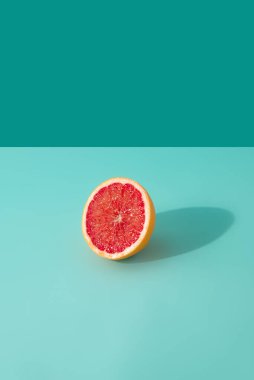 Nane mavisi arka planda kırmızı greyfurt dilimi. Asgari yaz konsepti.