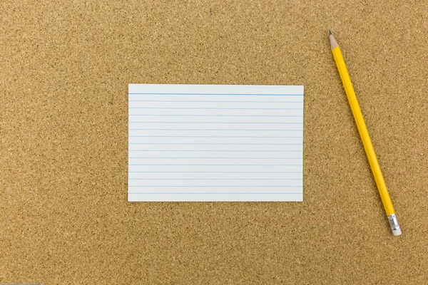 Lápiz con papel sobre tabla de corcho — Foto de Stock