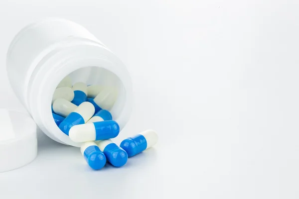 Сине-белые таблетки бутылка таблетки на белом фоне Лицензионные Стоковые Изображения