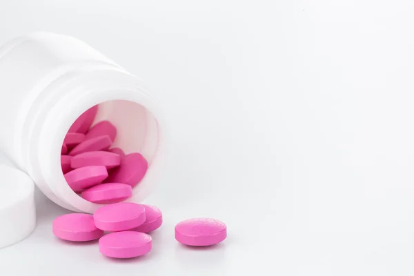 Pillole rosa una bottiglia pillola su sfondo bianco — Foto Stock