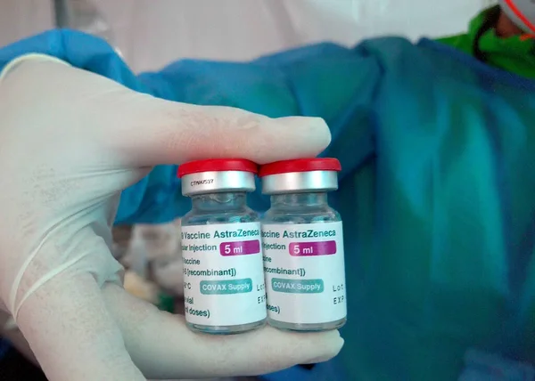 Hemşire elinde iki şişe Astra Zeneca covid19, covid-19 ya da Coronavirus aşısı tutuyordu. Bogota 'daki aşı sırasında eldiven ve mavi renk kullanıyordu.