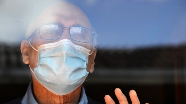 Portret Starszego Pana Okularach Masce Medycznej Spoglądającego Szybę Odbiciem Budynków — Wideo stockowe