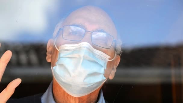 Портрет Пожилого Человека Очках Медицинской Маске Смотрящего Стеклом Отражением Зданий — стоковое видео
