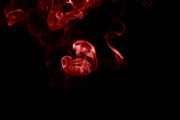 Red smoke on black background. Heart shaped smoke