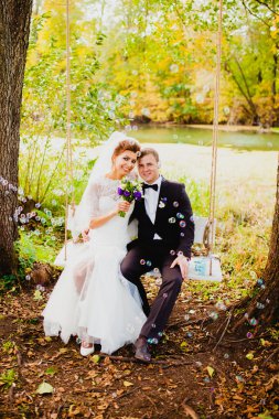 Gelin ve damat bir salıncak ve uçan baloncuklar