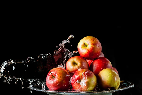 The apples lying on the silver side and flying water — Stock Photo, Image