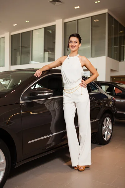 Piękna dziewczyna w białej sukni stojącej obok samochodu — Zdjęcie stockowe