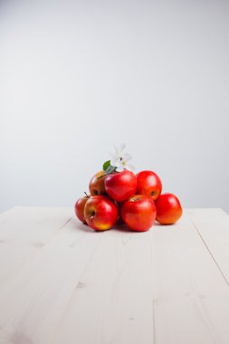 Çiçekli beyaz zemin üzerinde bir kaç Kırmızı elma